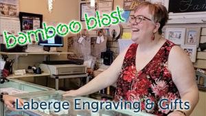 Bamboo blast, Laberge Engraving, Pauline smiling while standing behind a counter